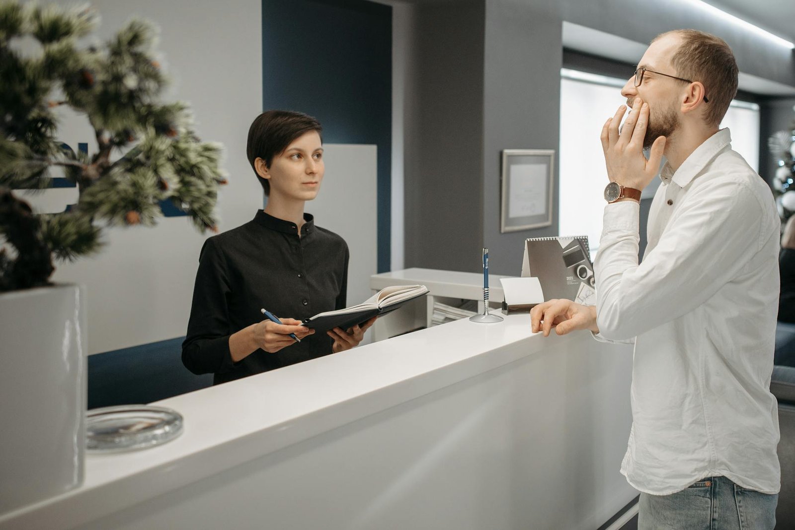 patient with toothache scheduling appointment with receptionist