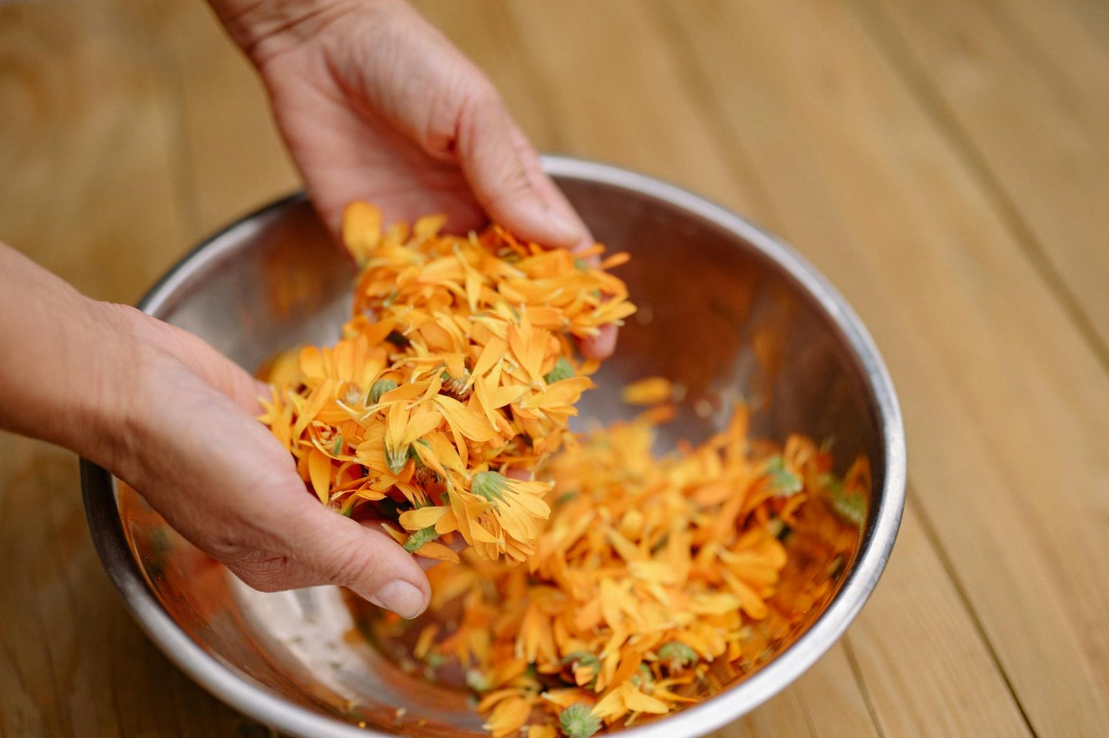 hands holding petals over bowl